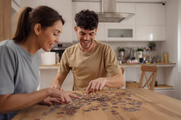 istock Happy couple having fun with puzzles during creative time at home. 2152160697