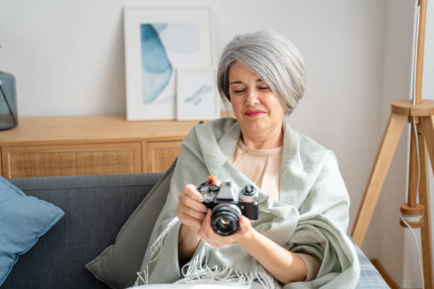 istock Senior woman with vintage camera indoors 2152161740