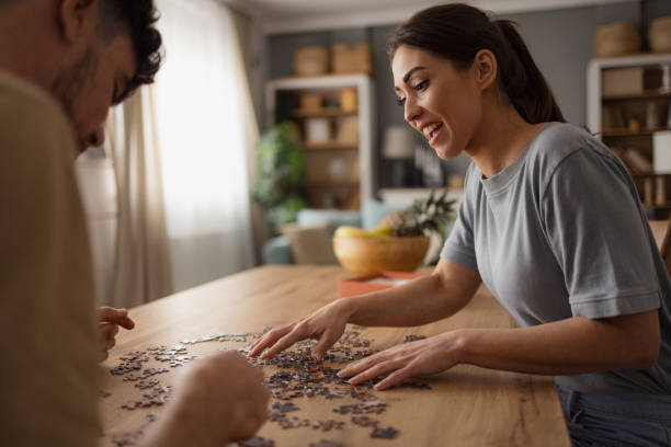 istock Happy couple playing with jigsaw puzzles at home. 2152163390