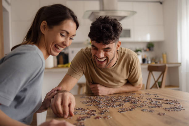istock Cheerful man and his girlfriend playing with puzzles at home. 2152163396