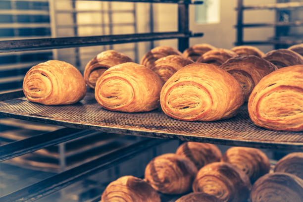 istock Freshly baked croissants on a shelf cart in a bakery 2152163497