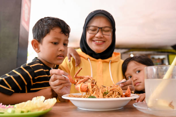 istock Mother and daughter eating noodles 2152163620