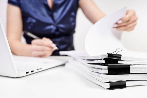 istock A stack of papers with Binder Clips against the background of an office worker working with documents 2152168056