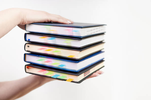 istock An office employee holds in his hands a stack of notebooks with colorful bookmarks on a light background 2152168151