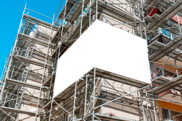 istock Blank white mockup advertisement hanging on the modern building under construction. Reconstruction of a building with white billboard. 2152168823