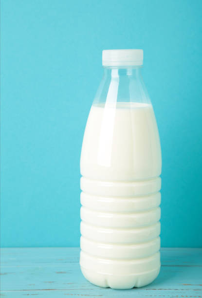 Bottle of milk on blue background. Vertical photo. Top view