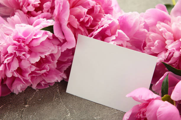 istock Mockup white greeting card with pink peonies on a grey background. 2152171084