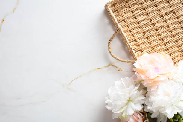 istock Empty wicker tray and bouquet of flowers on marble background. Top view. 2152173403