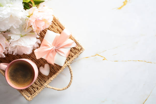 istock Top view wicker tray with gift box, flowers, coffee cup on marble table. Happy Mother's Day breakfast. 2152173675