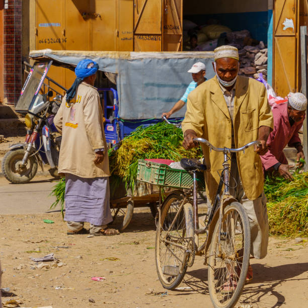 Rissani, Morocco - April 02, 2023: Market scene, with vegetable stalls, sellers, and shoppers, in Rissani, Sahara Desert, Morocco