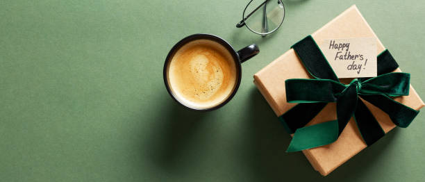 istock Happy Fathers Day gift box, coffee cup, glasses on dark green background 2152174806
