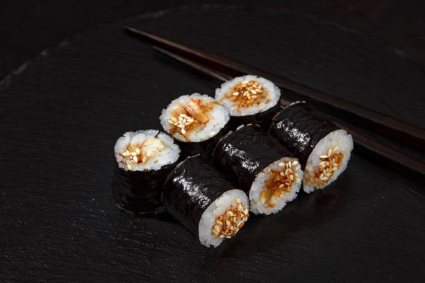 istock Traditional delicious freshsushi rolls with shrimp on a black background. Sushi roll with rice, cream cheese, avocado, salmon, sesame. Sushi menu. Japanese kitchen, restaurant 2152175004