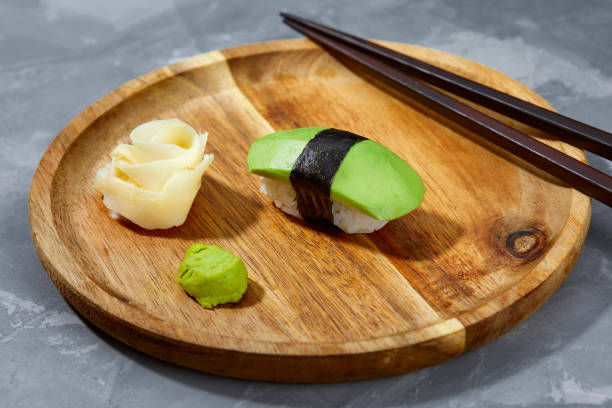 istock Sushi covered with avocado on wooden board gray stone background. 2152175569
