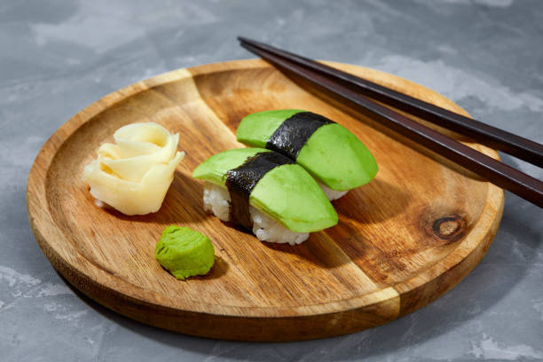 istock Sushi covered with avocado on wooden board gray stone background. 2152175570