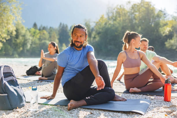 istock Group Enjoying Outdoor Yoga Session by the River 2152176222