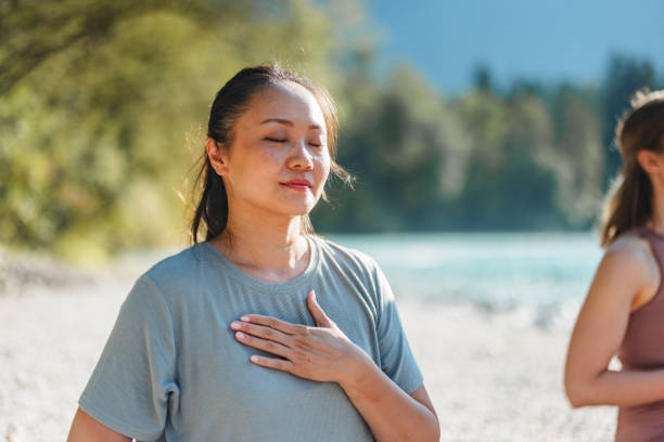 Woman Practicing Yoga Breathing Exercise by the River