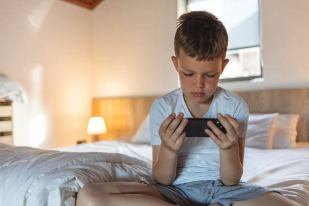 istock Boy using mobile smart phone at home. Child hands with a smartphone. Education, science, technology, children's security, internet safety concept. 2152176378