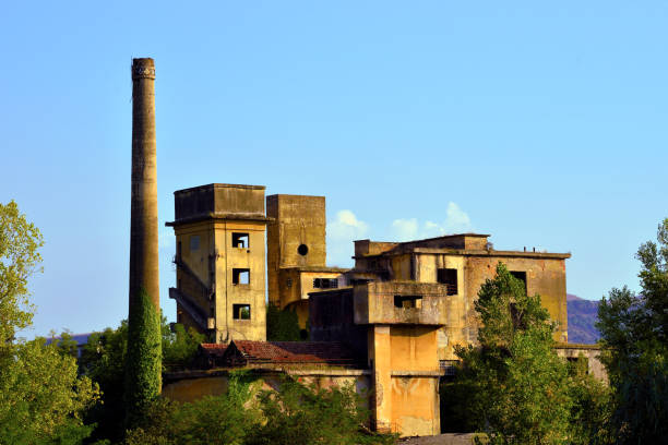 Old abandoned factory industrial plant. Fertilizer factory brick building ruins in Drapetsona Piraeus Greece, blue sky, sunny day.