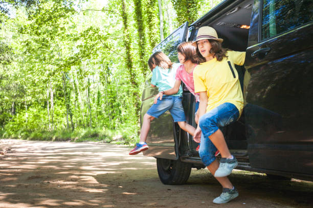 istock Three children are standing in the back of a van 2152179908