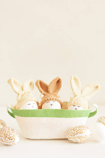 istock Easter eggs in crochet knitted hats with rabbit ears in nest. Easter celebration concept 2152181228