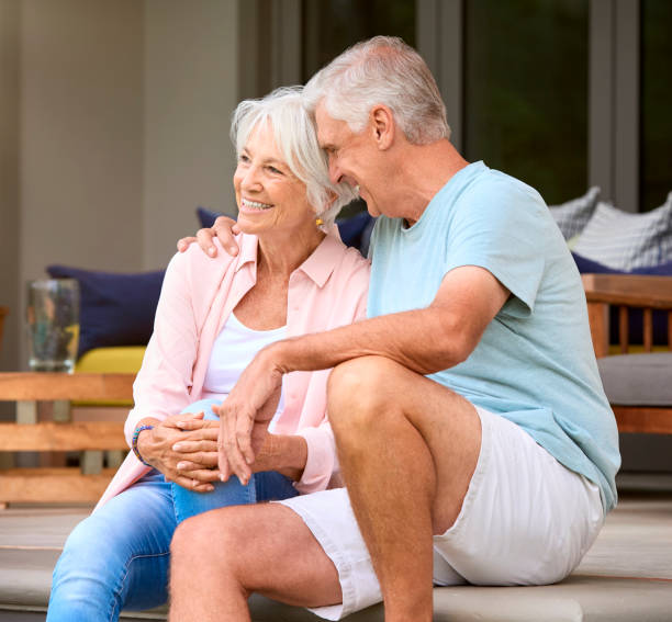 istock Loving Senior Couple Sitting Outdoors On Deck At Home Together 2152183681