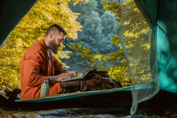istock Freelancer Traveler Working Online Using Laptop Outside the Tent 2152188103