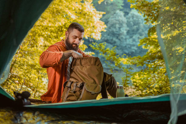 istock Bearded Young Man Relaxing Near Tent During a Hike 2152188733