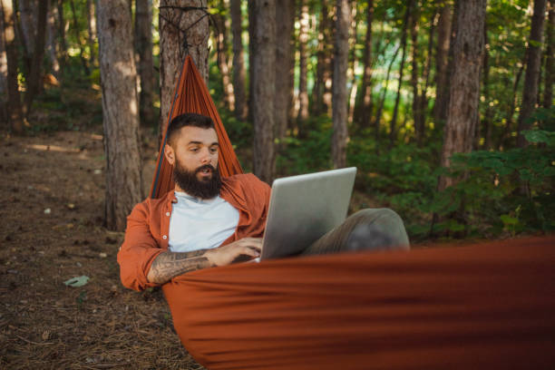 istock Freelance Man Using Laptop Working and Relax on the Hammock 2152188964