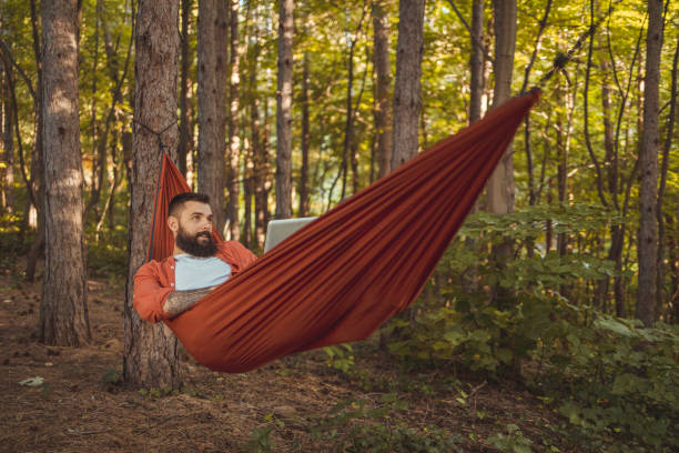 istock Freelance Man Using Laptop Working and Relax on the Hammock 2152189090