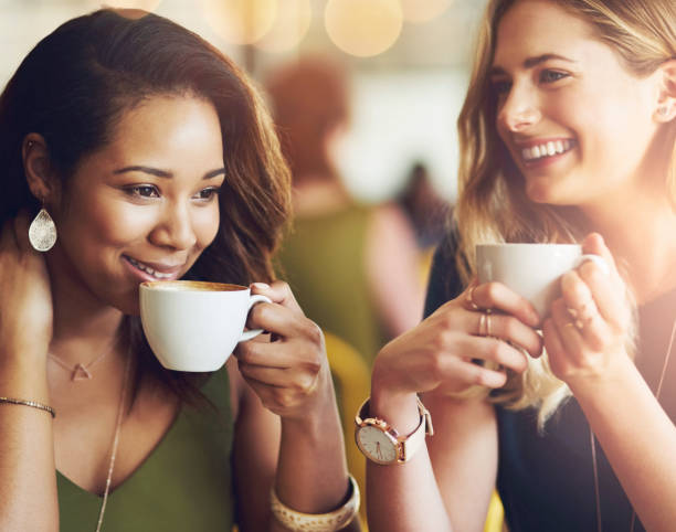 istock Smile, friends and women drinking coffee at cafe for conversation, communication or bonding. Happy girls, tea cup and talking at restaurant shop for morning gossip, story or relax together on bokeh 2152191682