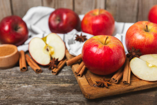 istock Apples with cinnamon on a textured wooden background. Fragrant red spiced apples with cinnamon sticks and star anise. Apple slices with spicy spices. Place for text. Copy space. Harvesting. Fruits. 2152196038