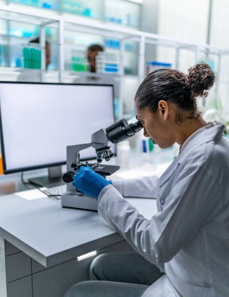 istock Multiple scientists at a medical laboratory. Female scientist using a microscope to examine the medical samples 2152197279