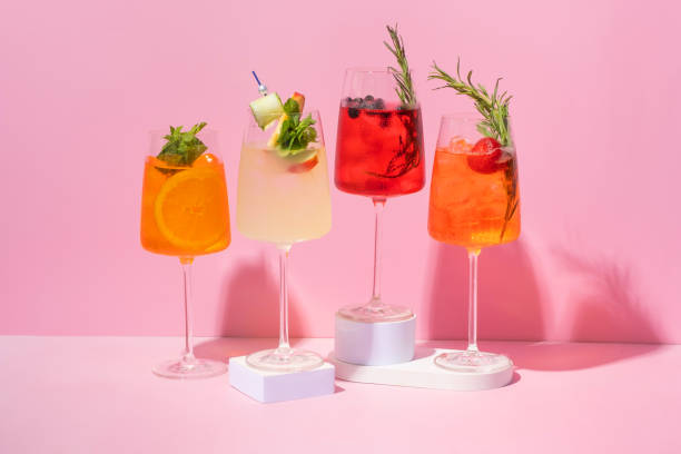 istock 4 glasses with alcoholic cocktails on podiums on pink background. 2152198596