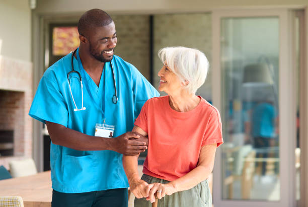 istock Male Nurse Visiting Senior Woman Using Walking Stick With Mobility Issues At Home 2152198832