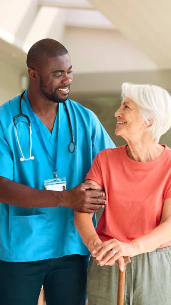 istock Male Nurse Visiting Senior Woman Using Walking Stick With Mobility Issues At Home 2152198867