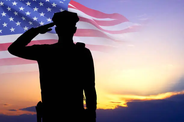 Silhouette of police man with USA flag against the sunset Silhouette of police man with USA flag against the sunset