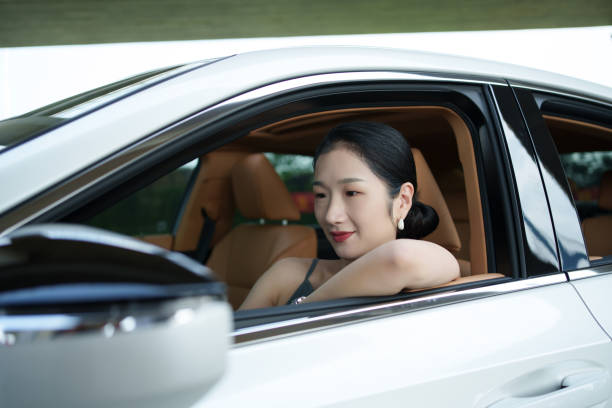 Asian woman leaning on car window