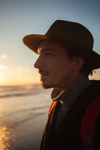 istock Reflective moment as man walks seashore under fading light. 2152204171