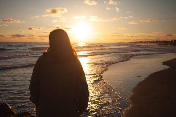 istock Sunset beach walk for serene woman. 2152204189
