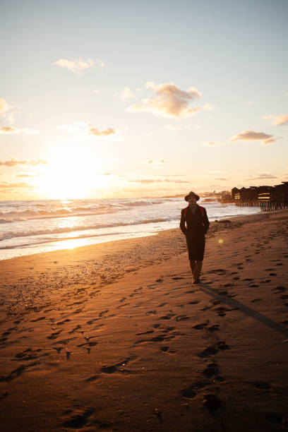 istock Calm evening man walks by ocean under colorful sky. 2152204237