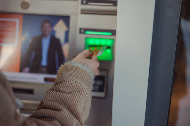 Beautiful young woman taking the money from the ATM machine for shopping