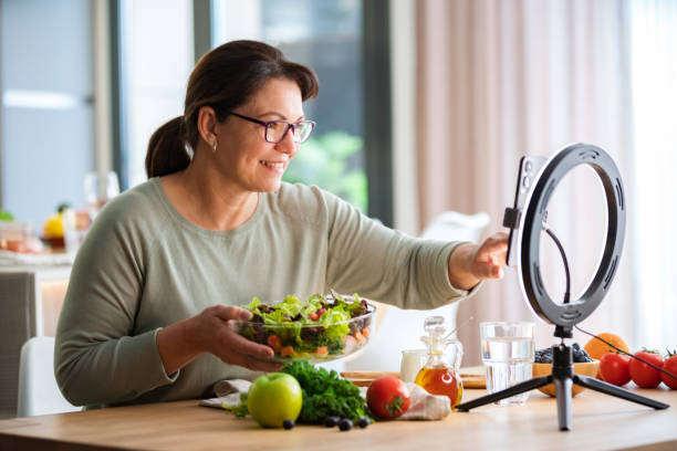 istock Woman preparing salad and streaming online healthy eating masterclass lesson 2152213608