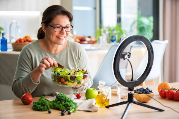 Woman blog about healthy eating, using smartphone and ring light