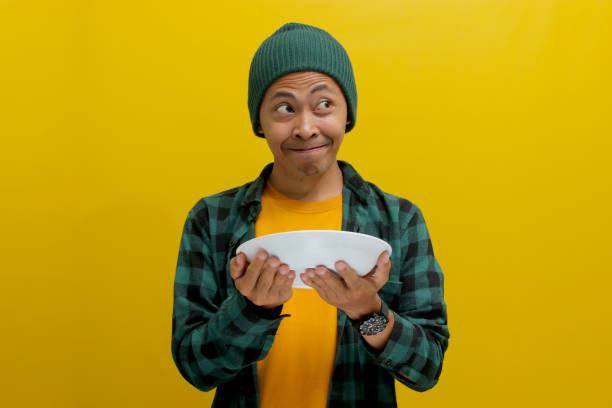 istock Hungry young Asian man holding a plate in his hand 2152215878