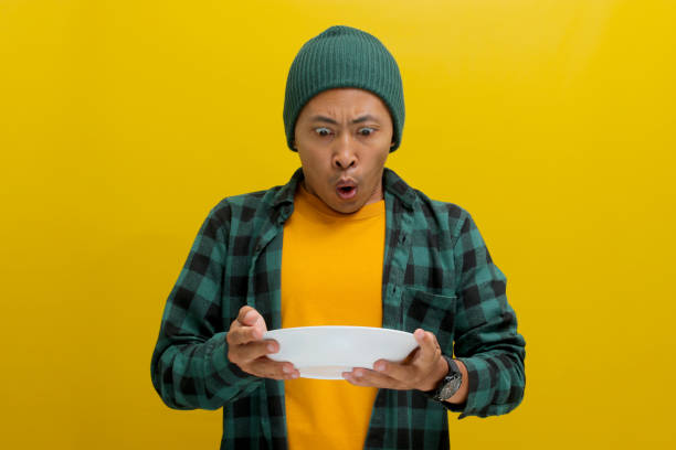 istock Surprised Young Asian man is holding an empty white plate in his hand 2152217416