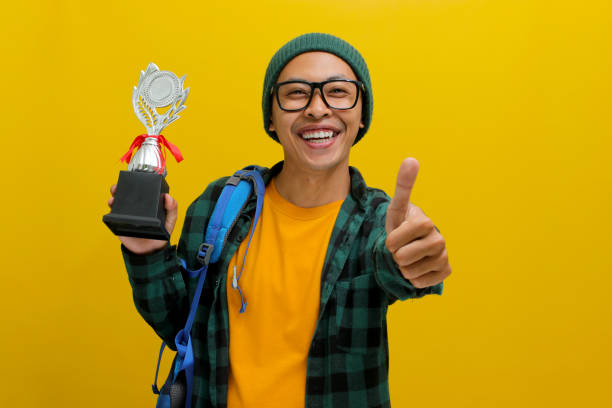 istock Excited Asian student joyfully giving a thumbs up to the camera 2152217630