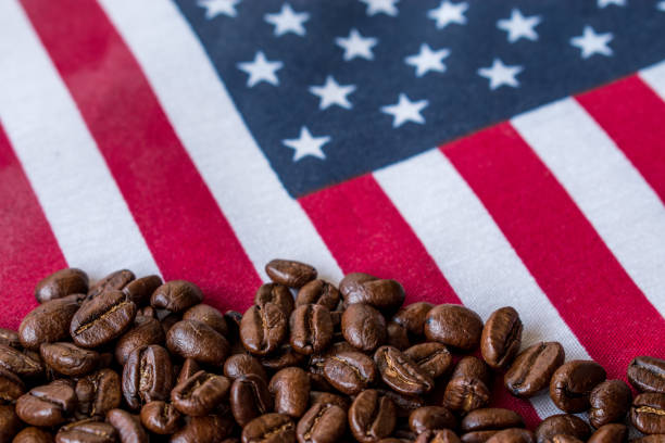 Some roasted black coffee beans on USA flag background with copy space