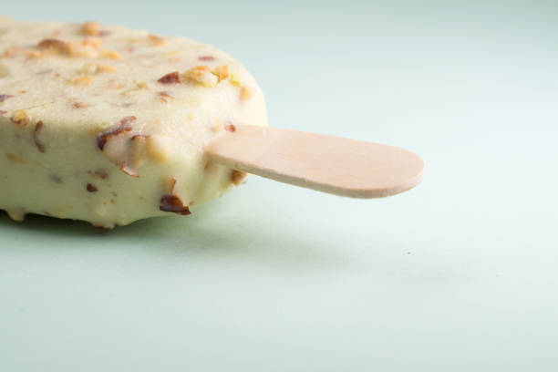 Close up of pistachio ice cream with pistachio bits on blue background and copy space