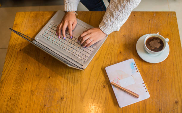 istock hands of a woman using her laptop and different objects around it 2152222014