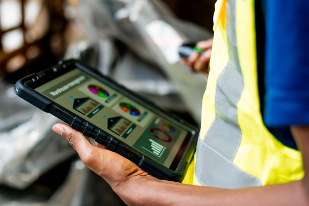 Warehouse Worker Monitoring Inventory on Digital Tablet